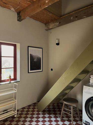 a staircase in a room with a washing machine at Farmhouse in historic village in Österlen in Glemminge