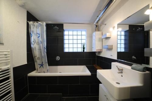 a bathroom with a tub and a sink and a bath tubermottermott at NEW Luxury Apartment in Heilbronn Neckarsulm in Heilbronn