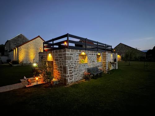a house in a yard at night with lights at L’ÉCURIE in Gigny