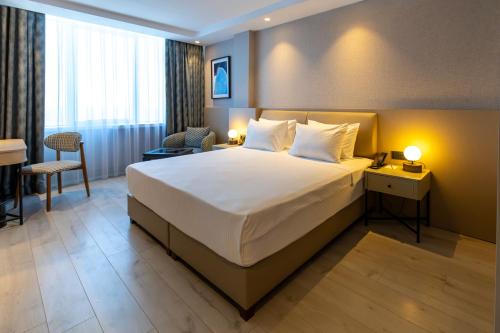 a hotel room with a large bed and a desk at Delta Hotels by Marriott Antalya Lara - Adult Only 18 Plus in Antalya