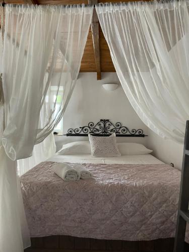 a bedroom with a bed with white curtains at Matsas Mansions in Chora Folegandros