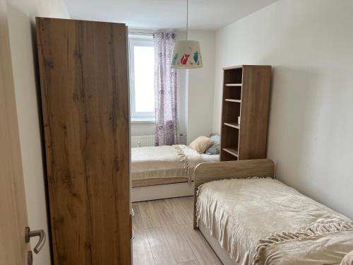a bedroom with two beds and a large wooden door at COZY apartment in GREAT location in Košice