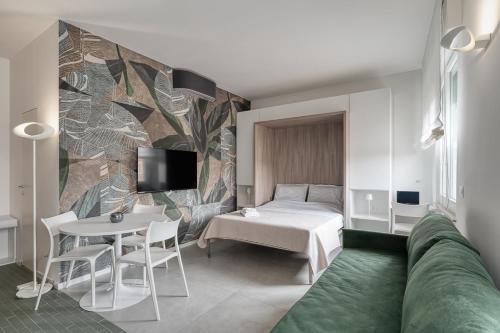 a room with a bed and a table and a tv at Via Fiasella - Le Case di Bart in Genoa