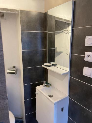 une salle de bain avec un lavabo et un miroir dans l'établissement Paradis, à Hyères