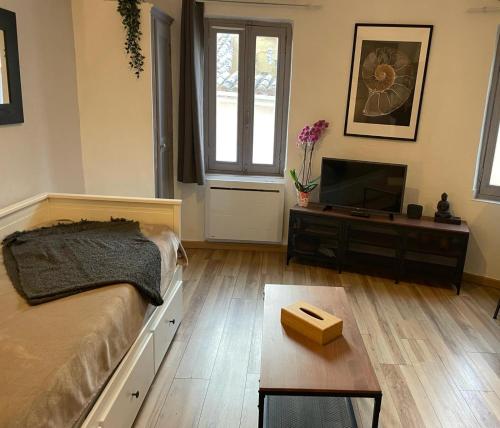 une chambre avec un lit et une télévision à écran plat dans l'établissement Paradis, à Hyères