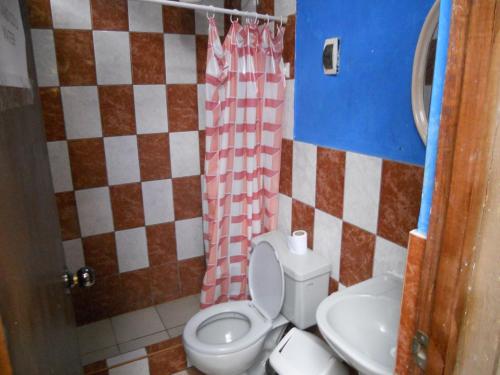 a bathroom with a toilet and a sink at El Mochilero in Trujillo