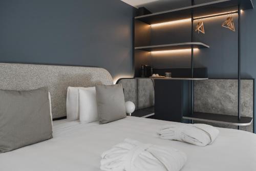 a bedroom with a bed with white sheets and pillows at Hotel Admiral Lugano in Lugano