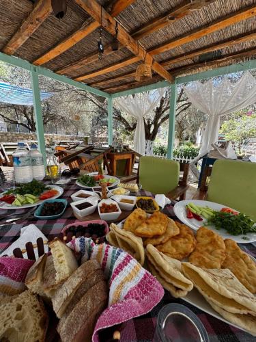 a table with bread and other food on it at KARABURUN KÖYEVİ Pansiyon in Saip