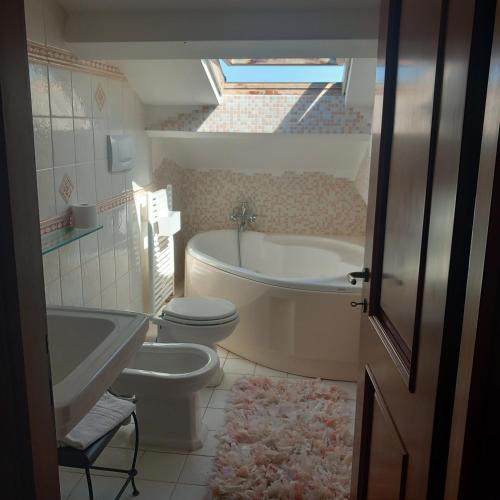 a bathroom with a toilet and a tub and a sink at casa vacanza GIOIA in Civitanova Marche