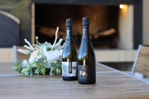 two bottles of wine sitting on a wooden table at Copanjek Country House in Plešivica