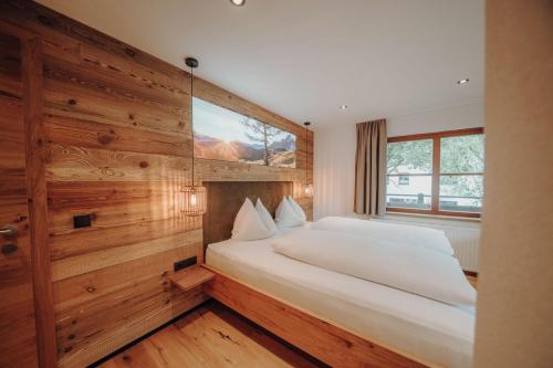 a bedroom with a large bed in a wooden wall at Frühstückspension Friedheim in Filzmoos