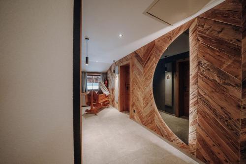 a hallway with a wooden wall with a mirror at Frühstückspension Friedheim in Filzmoos