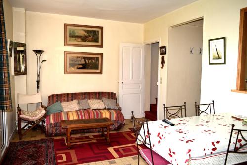 a living room with a couch and a bed at Maison derrière les champs in Itteville