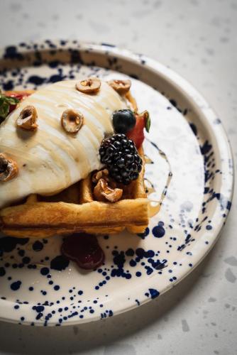 a plate with a waffle with fruit on it at Hotel Admiral Lugano in Lugano