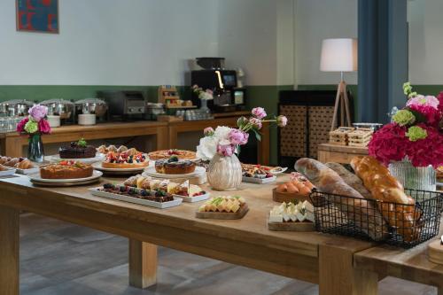 a table filled with different types of desserts and pastries at Hotel Admiral Lugano in Lugano