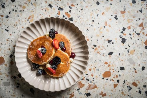 a paper plate with pancakes with berries on it at Hotel Admiral Lugano in Lugano