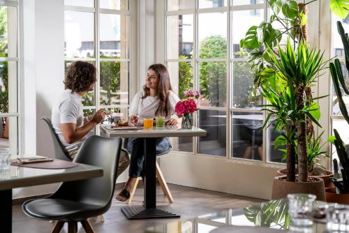 a man and woman sitting at a table in a restaurant at Hotel Admiral Lugano in Lugano
