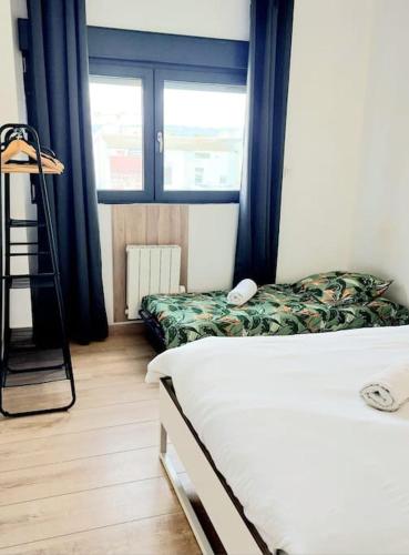 a bedroom with a bed and a ladder and windows at "Le Relax" - Velaux appart climatisé - 6 pers avec terrasse à 15 min plage et aéroport in Velaux
