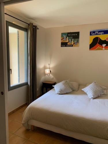 une chambre avec un grand lit blanc avec deux oreillers dans l'établissement appartement cosy avec climatisation réversible GOLF DE SAUMANE, à Saumane-de-Vaucluse