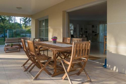 - une table et des chaises en bois sur la terrasse dans l'établissement Belle villa au Cap Ferret Quartier MIMBEAU, à Lège-Cap-Ferret