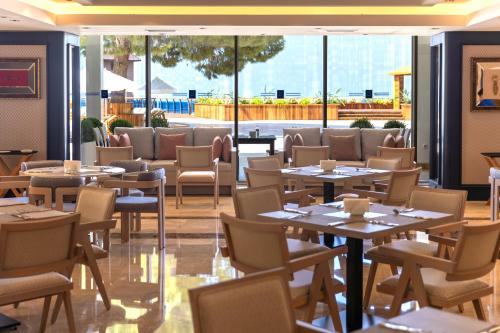 a restaurant with tables and chairs and windows at Delta Hotels by Marriott Antalya Lara - Adult Only 18 Plus in Antalya