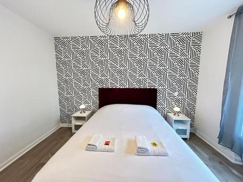 a bedroom with a bed with a black and white patterned wall at Forum Graphic magnifique T2 spacieux au centre in Reims