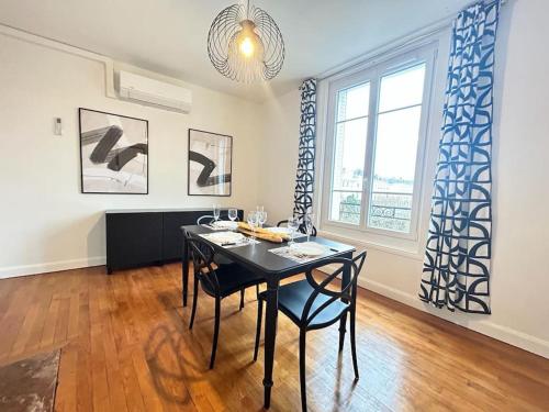 une salle à manger avec une table et des chaises noires dans l'établissement Forum Graphic magnifique T2 spacieux au centre, à Reims