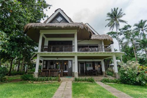 a house with a thatched roof at Daluyon Beach and Mountain Resort in Sabang
