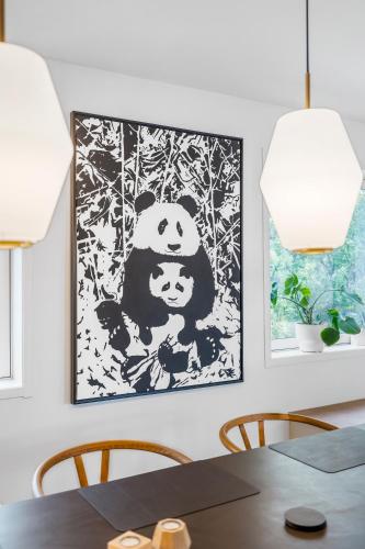 a dining room with a panda picture on the wall at Kais sauna, jacuzzi, cinema and balcony house! Central location in Tromsø