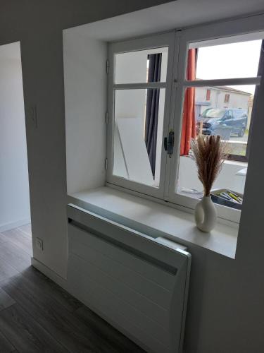 ein Fenster mit einer Vase auf einem Fensterbrett in der Unterkunft Amelixis in Chaillé-les-Marais