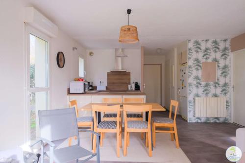 une cuisine et une salle à manger avec une table et des chaises dans l'établissement Appartement Biscarrosse joli T3 avec terrasse et jardin privatif classé 1 étoile, à Biscarrosse