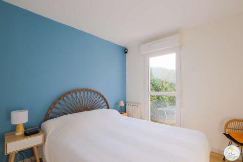 une chambre avec un lit blanc et une fenêtre dans l'établissement Appartement Biscarrosse joli T3 avec terrasse et jardin privatif classé 1 étoile, à Biscarrosse