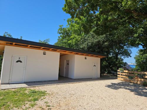 a garage with white doors and a wooden roof at Glamping Imotski 5 in Imotski