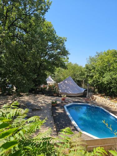 a backyard with a swimming pool and a tent at Glamping Imotski 5 in Imotski