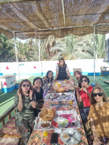 a group of women sitting around a table with food at ABAZIDO Nubian Guest House in Aswan