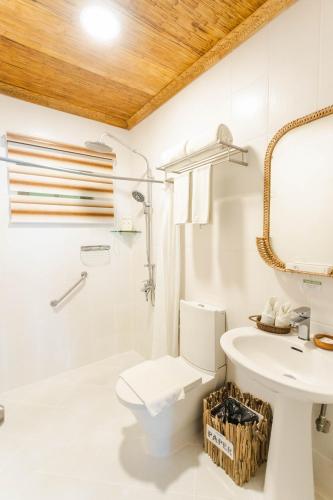a white bathroom with a sink and a toilet at Daluyon Beach and Mountain Resort in Sabang