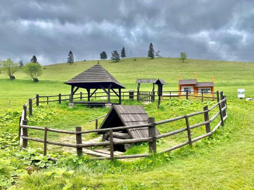 a farm with a fence and a gazebo in a field at Chalet Durik Bystra - Jacuzzi - Sauna - In the forest - 10 min walk to restaurant - On hiking trail in Horná Lehota