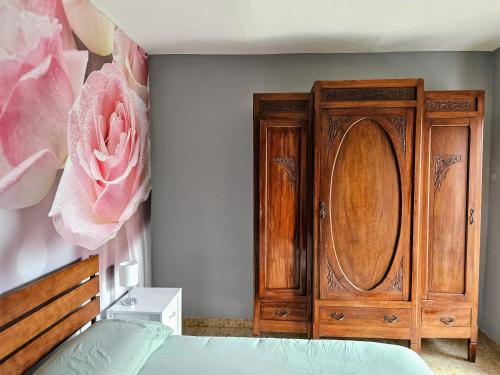 a bedroom with a wooden cabinet next to a bed at Casa Margherita - MonferratoHome in Cuccaro Monferrato