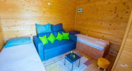 a sauna with a blue couch and a table at Retro Pool House in Mostar