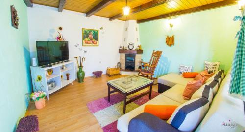a living room with a couch and a tv at Retro Pool House in Mostar