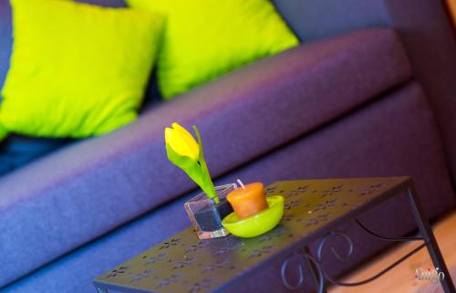 a small table with a flower on a couch at Retro Pool House in Mostar