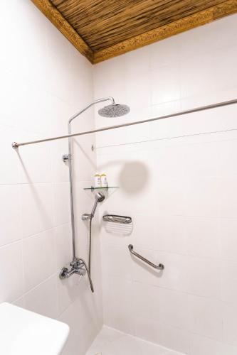 a white bathroom with a shower and a sink at Daluyon Beach and Mountain Resort in Sabang