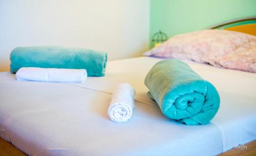 a bed with two rolled towels on it at Retro Pool House in Mostar