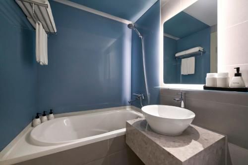 a bathroom with a tub with a bowl on it at Signature by M Village Thợ Nhuộm in Hanoi