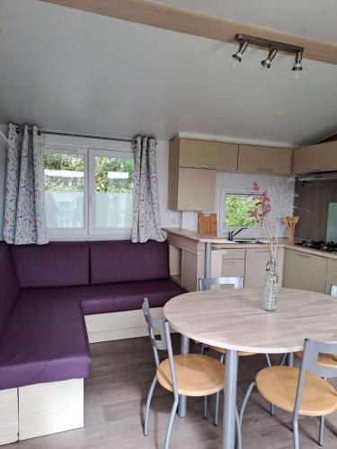 une cuisine et un salon avec une table et des chaises dans l'établissement Camping le Kergorz, à Plomodiern