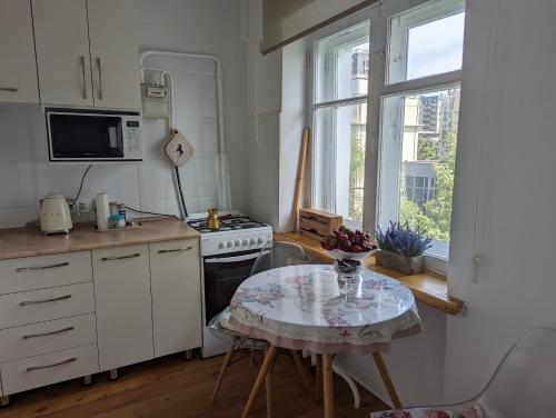 cocina con mesa, fogones y ventana en Moonflower residence 4645, en Bishkek
