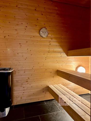 a sauna with a clock on a wooden wall at Large log cabin at Sjusjøen with sauna, fireplace and panoramic view in Ringsaker