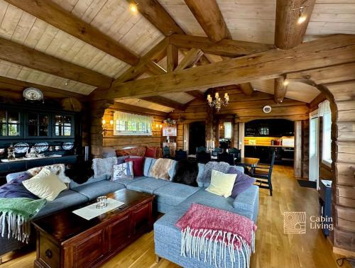 a living room with a blue couch in a cabin at Large log cabin at Sjusjøen with sauna, fireplace and panoramic view in Ringsaker