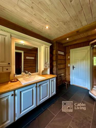 a large bathroom with a sink and a mirror at Large log cabin at Sjusjøen with sauna, fireplace and panoramic view in Ringsaker