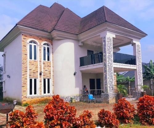 a small white house with a gambrel roof at 3 bedroom duplex in Rumu-Oparala